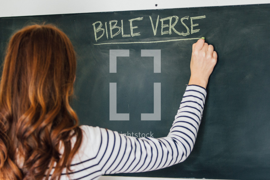 a woman writing on a chalkboard Bible verse 