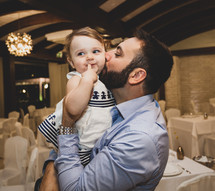 Young happy dad kissing daughter on cheek