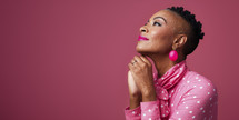 Thoughtful African American woman in a pink polka dot blouse with matching accessories, gazing upwards.