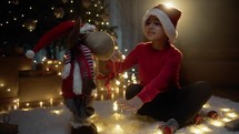 Child putting lights on a Christmas puppet 