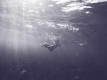 a woman swimming under water 