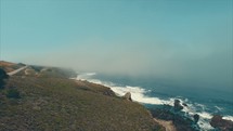 Flying over a coastline | Tide washing onto a shore | Summer | Sand | Motion | Movement | Aerial | Waves | Vacation | Overhead Shot | Dolly Shot | Angles | California | Creation | Nature | Landscape | God | Rocks | Flying | Sky | Land | Mountain | Fog 