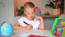 Child Kid Girl doing her homework art a desk. Education concept. Cute smart school child girl writing doing homework.	
