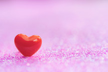 single red heart on a pink background 