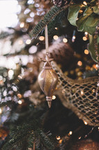 gold Christmas ornament hanging on a Christmas tree 