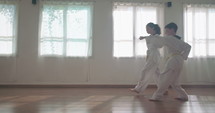 Slow motion footage of young kids practicing martial arts