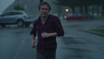 a man running outdoors in the rain in slow motion 