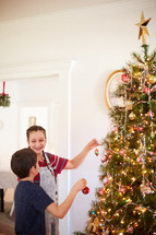 children decorating a Christmas tree 