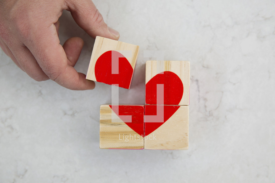 building a red heart out of wood blocks.