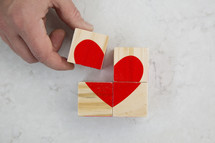 building a red heart out of wood blocks.