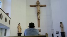 a man in prayer at church in front of an altar 