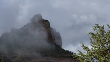 Time lapse of clearing fog over a rugged desert mountain