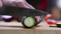 Close up of a man slicing fresh veggies on a cutting board