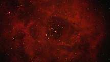 Zoom-out of a large nebula in deep space that resembles a rose