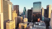 Aerial video of downtown Dallas, Texas during sunrise with highways, traffic and skyscraper buildings in the background.