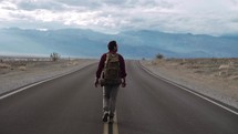 a man hiking alone on a desert highway 