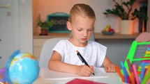 Serious Girl kid primary class student write exercise homework home learning education. Distance learning school. child at home in a lesson virtual. Clever happy little girl. 