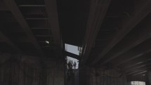 people walking down steps under an overpass 