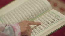 Close Up Hand Reading The Quran Qur'an or Koran religious text of Islam, believed by Muslims to be a revelation from God