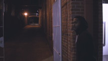 a man walking down a dark alley at night 