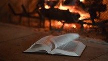flames in a fireplace and open Bible 