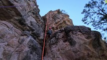 A man rock climbing on a high canyon wall