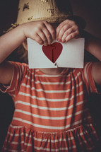 a child holding a heart puzzle 