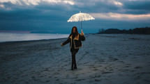 Glowing umbrella of a women walking on the beach in the night outdoor