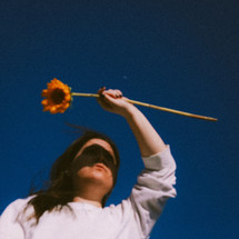 A young woman holding a sunflower 