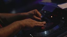 DJ's hands on a sound board.