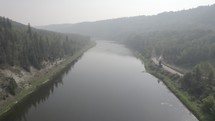Drone shot of a river in canyon with smokey atmosphere. 
