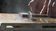 A flooring contractor cutting tile on a wet saw