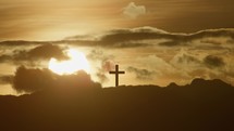 Crucifix on mountain top at sunset