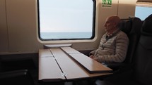 Elderly man is traveling by train