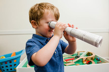 child with a paper telescope 