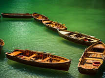 rowboats floating on green waters 
