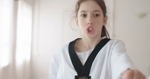 Slow motion footage of a girl practicing martial arts in a dojo.