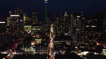 Aerial night drone shot of urban downtown in Toronto, Canada. Drone flying over the financial district with high traffic congestion. Slow camera movement forward. Illuminated and modern cityscape.