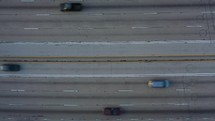 Drone hovering over freeway with traffic passing by