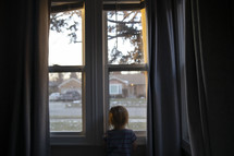 a toddler looking out a window 