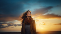 Middle aged caucasian woman looking up at the sky at sunset. 
