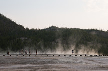 people walking on a steamy lake shore 