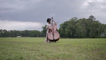 woman playing a cello outdoors 