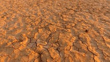 Aerial of cracked earth in a vast desert during drought conditions