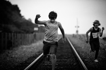 boys running on train tracks 