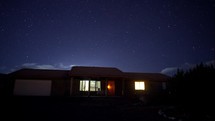 Time lapse of stars over a house on a peaceful night