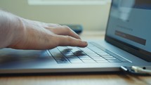 Man hands typing on a laptop computer keyboard