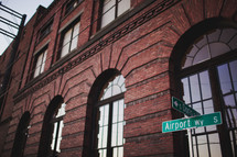street signs in front of a brick warehouse building