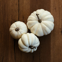 white pumpkins on a wood floor 