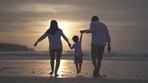 Portrait of Asian Indonesian Happy Family Father Mother and Child Spending Time Together at The Beach during Sunset - Relationship, Bond, Parenting, Laugh and Love